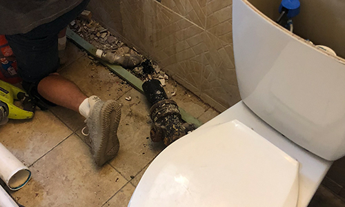 Water damage, crumbling wall inside bathroom.